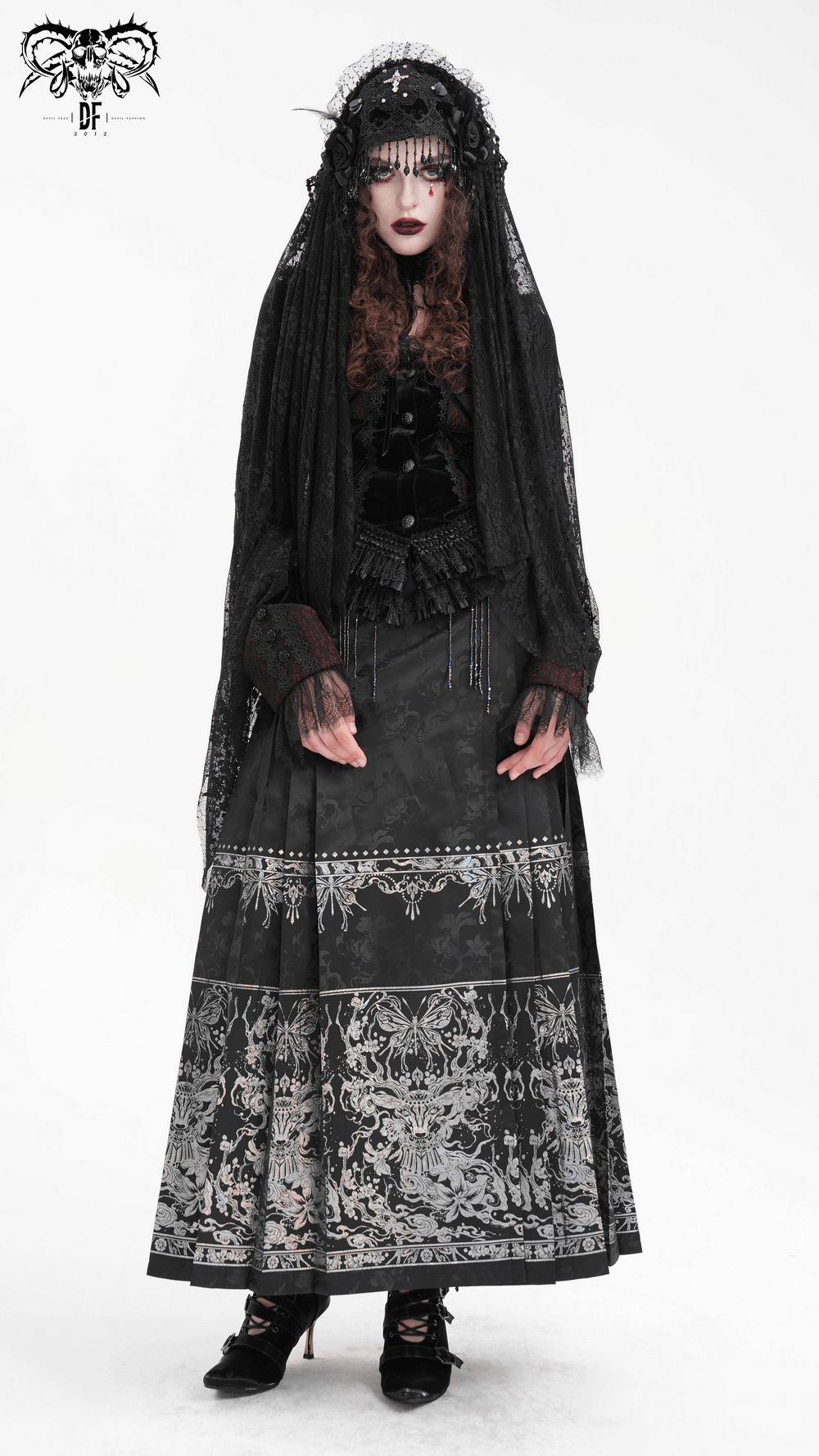 Model in flowing black gothic skirt with intricate embroidery and embellished details, paired with a stylish black top.