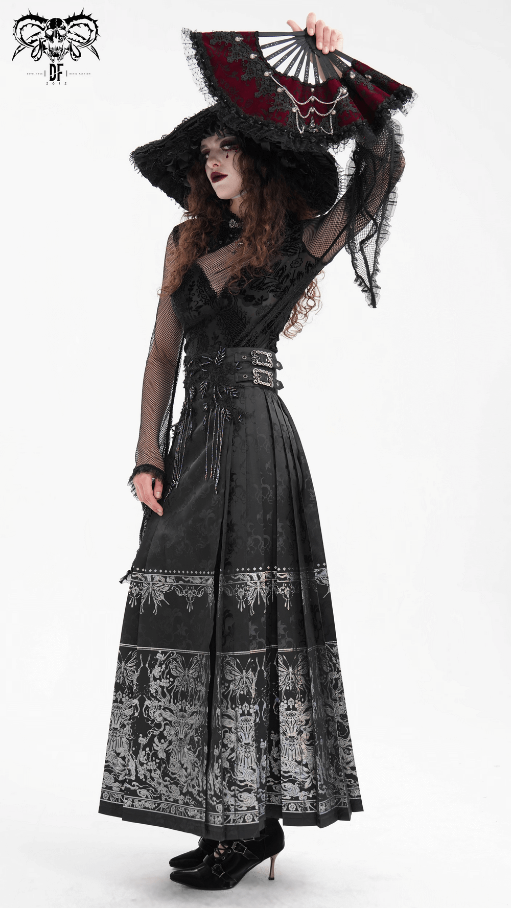 Gothic black skirt with embroidered details, flowing silhouette, and embellished waistband, styled with a fan and dramatic hat.