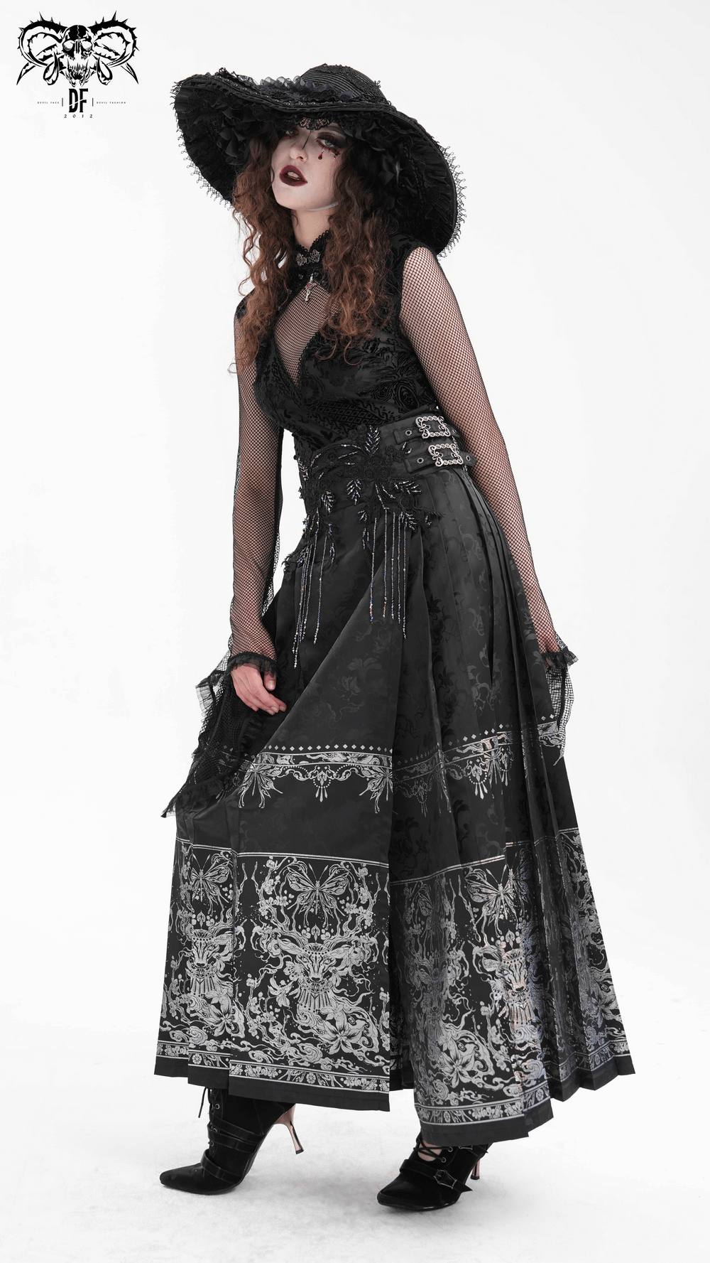 Gothic long black skirt with intricate embroidery and embellished details, styled with a dramatic hat.