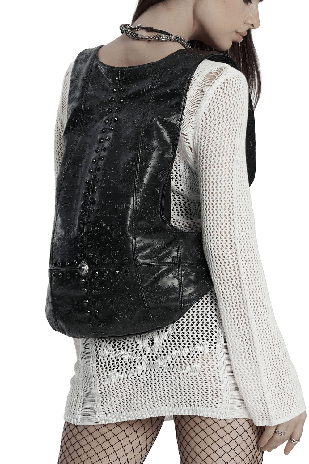 Gothic faux leather backpack with skull pattern, worn stylishly over a mesh top, showcasing edgy fashion.