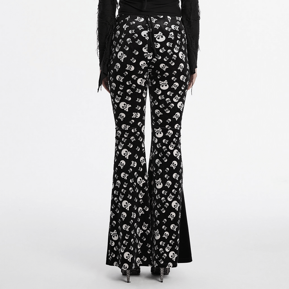 Gothic skull print flared pants with black velvet panel design, highlighting feminine curves and alternative fashion style.