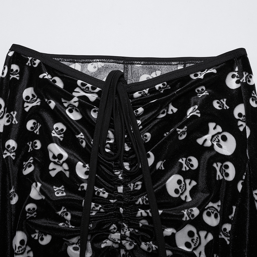 Close-up of Gothic skull print flared pants featuring ruched front and high waist, crafted in soft black velvet.