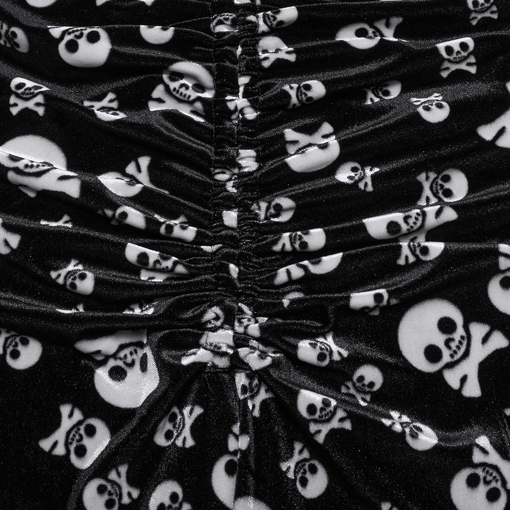 Close-up of Gothic skull print velvet fabric with ruched detailing for flared pants, showcasing bold black and white skull pattern.