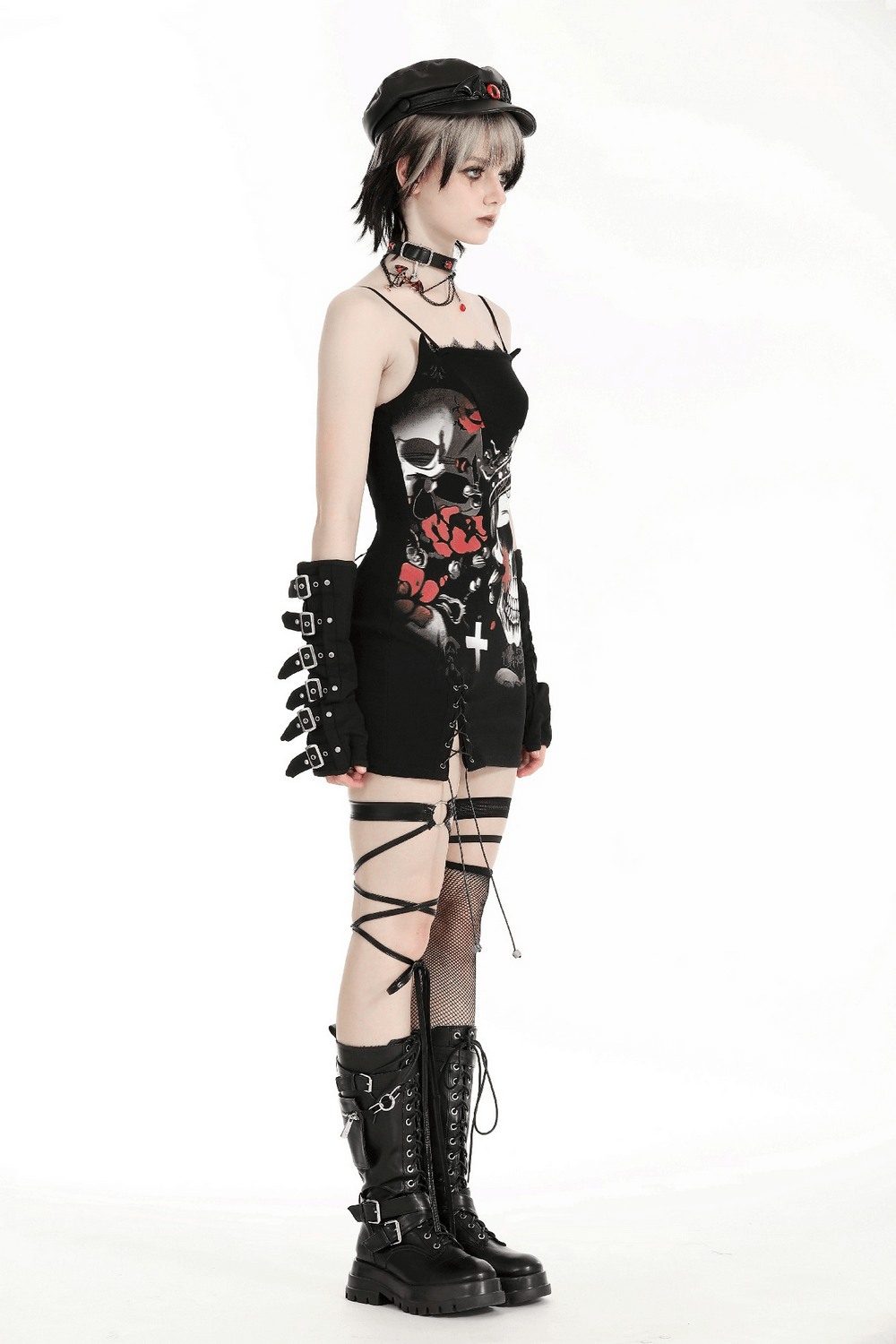 Gothic skull print sleeveless mini dress with lace detail, styled with edgy accessories and bold lace-up boots.