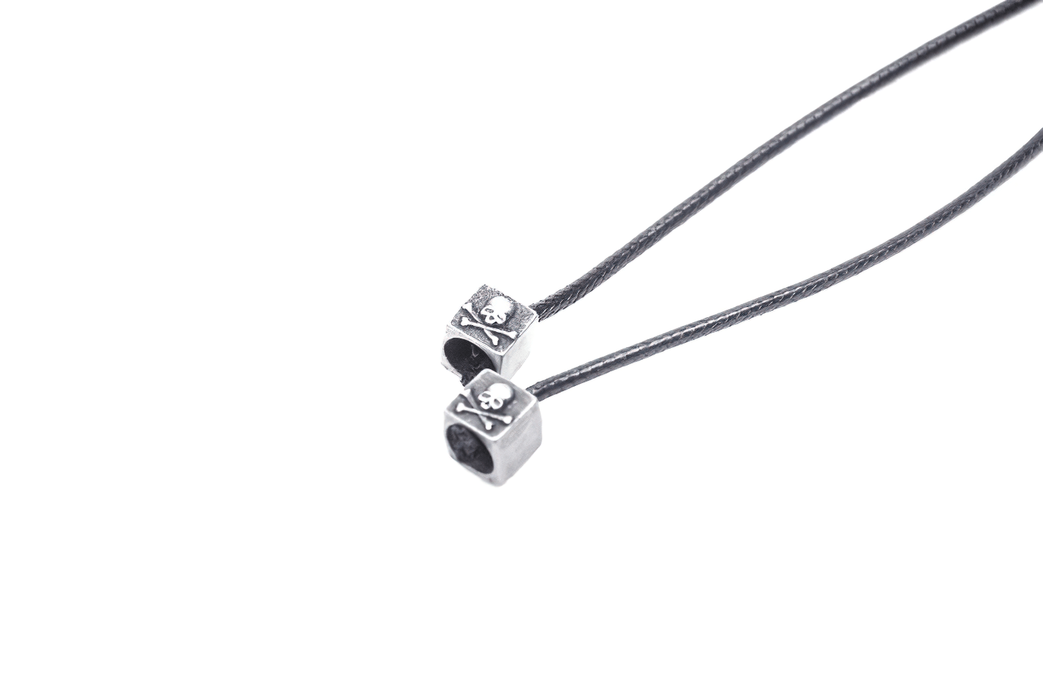 Gothic skull charm beads on a black cord necklace, perfect for alternative fashion lovers and unique accessories.