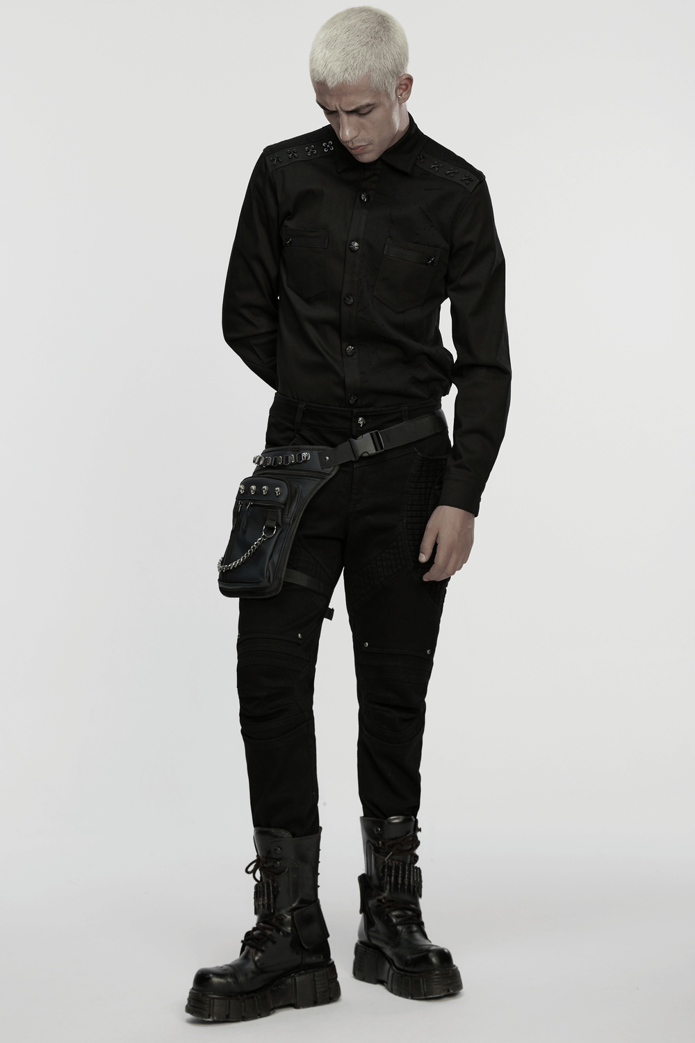 Gothic skull waist and leg bag with chains, worn by a model in black attire and boots, showcasing edgy fashion.