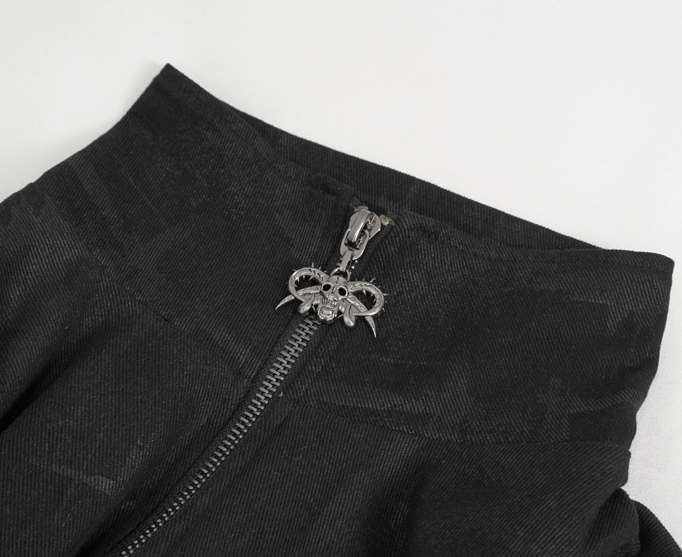 Close-up of gothic skull zipper on men's asymmetric coat showcasing dark charm and unique design.