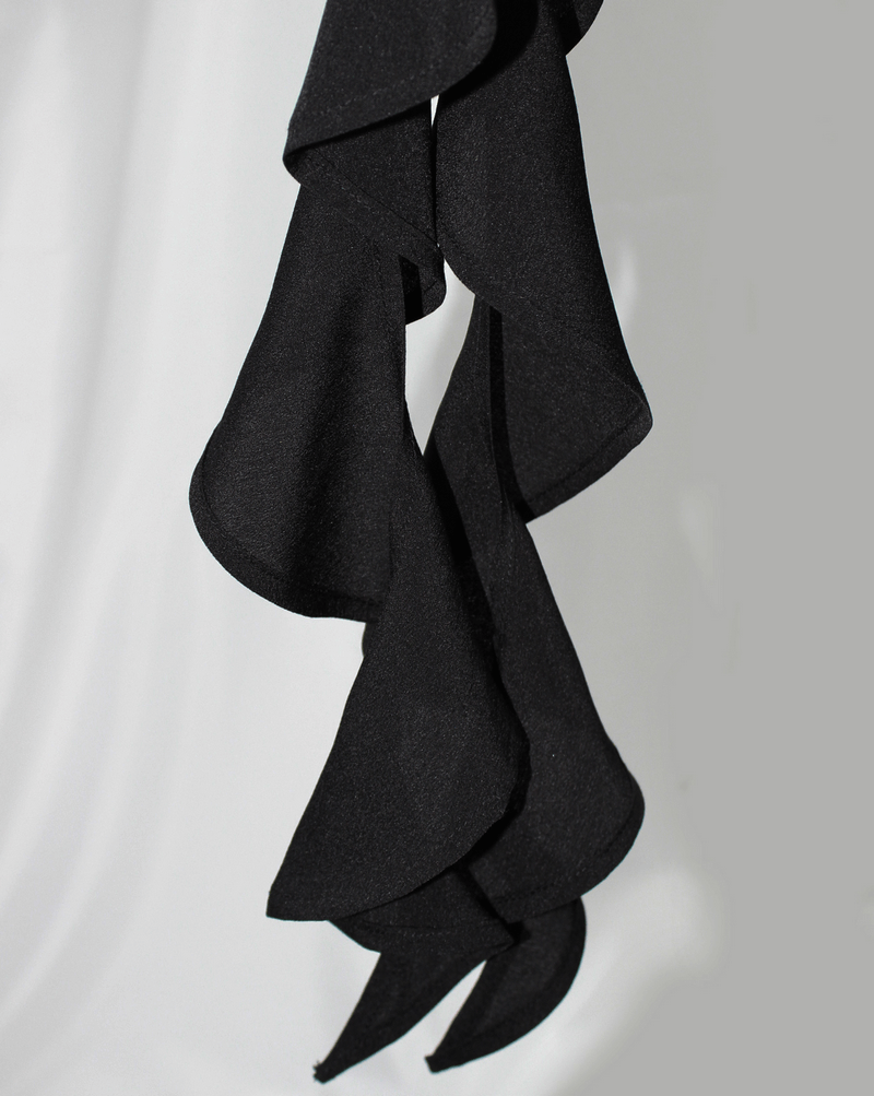 Gothic black blouse detail featuring wavy ruffles and elegant drapes for a stylish look.
