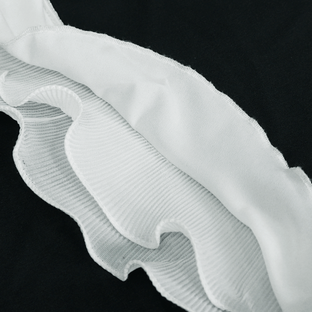 Close-up of wavy ruffles on a gothic women's white blouse, showcasing intricate detailing and texture.