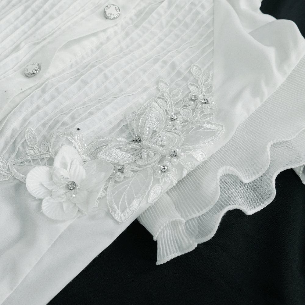 Gothic sleeveless white blouse with floral embroidery and wavy ruffles, featuring vintage buttons for a stylish look.