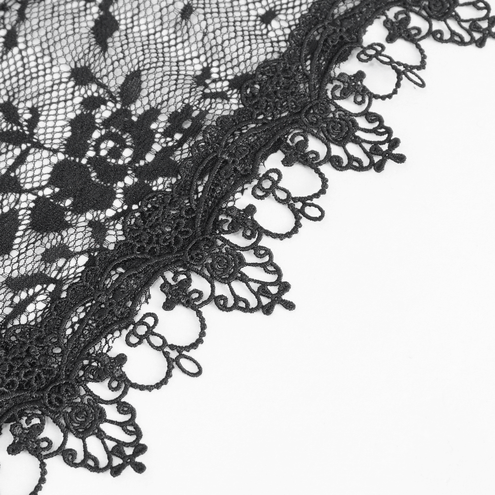 Close-up of intricate black lace fabric with floral patterns and elegant scalloped edges.