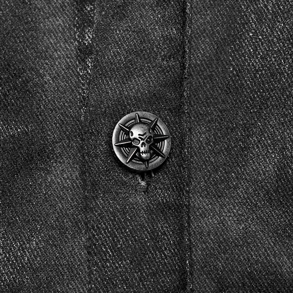Close-up of a gothic skull button on a black shirt, showcasing unique decorative detailing.