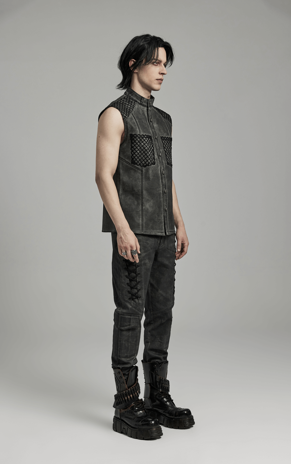 Gothic sleeveless shirt with mesh detailing and pockets, paired with gothic style pants and edgy shoes.