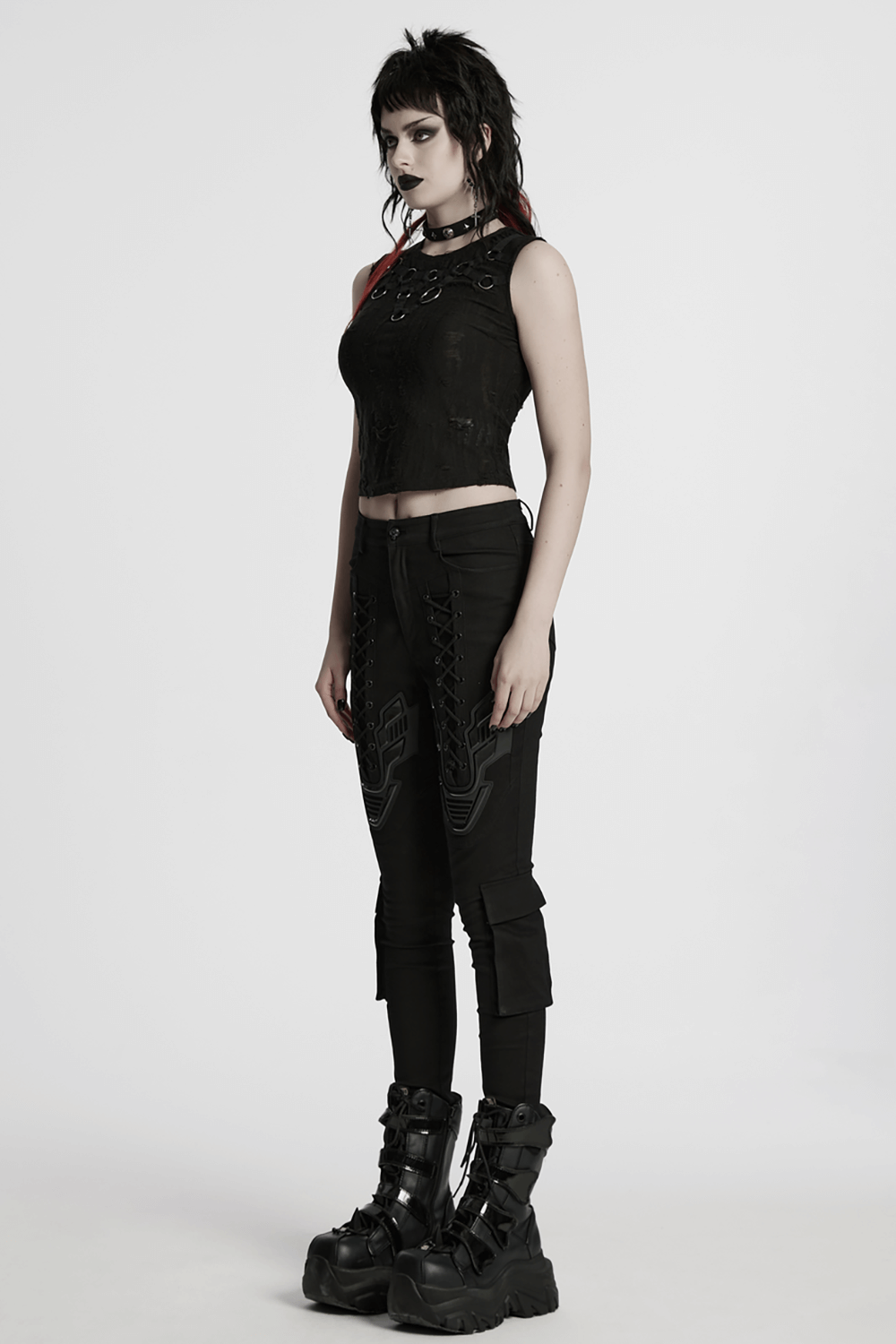 Gothic sleeveless top with iron rings, paired with black pants and chunky boots, showcasing punk fashion.