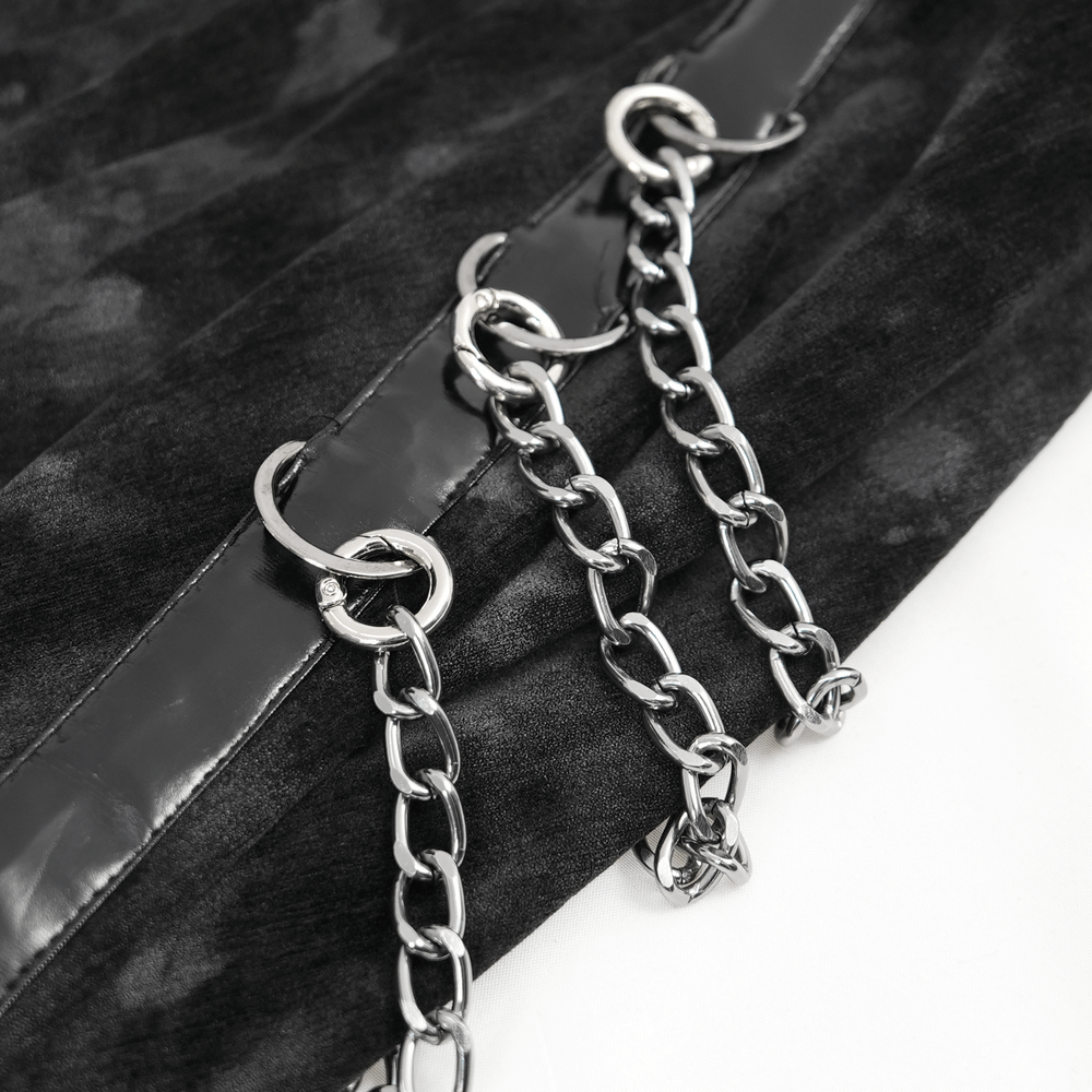 Close-up of silver chains on black velvet fabric, highlighting the Gothic design elements of the dress.