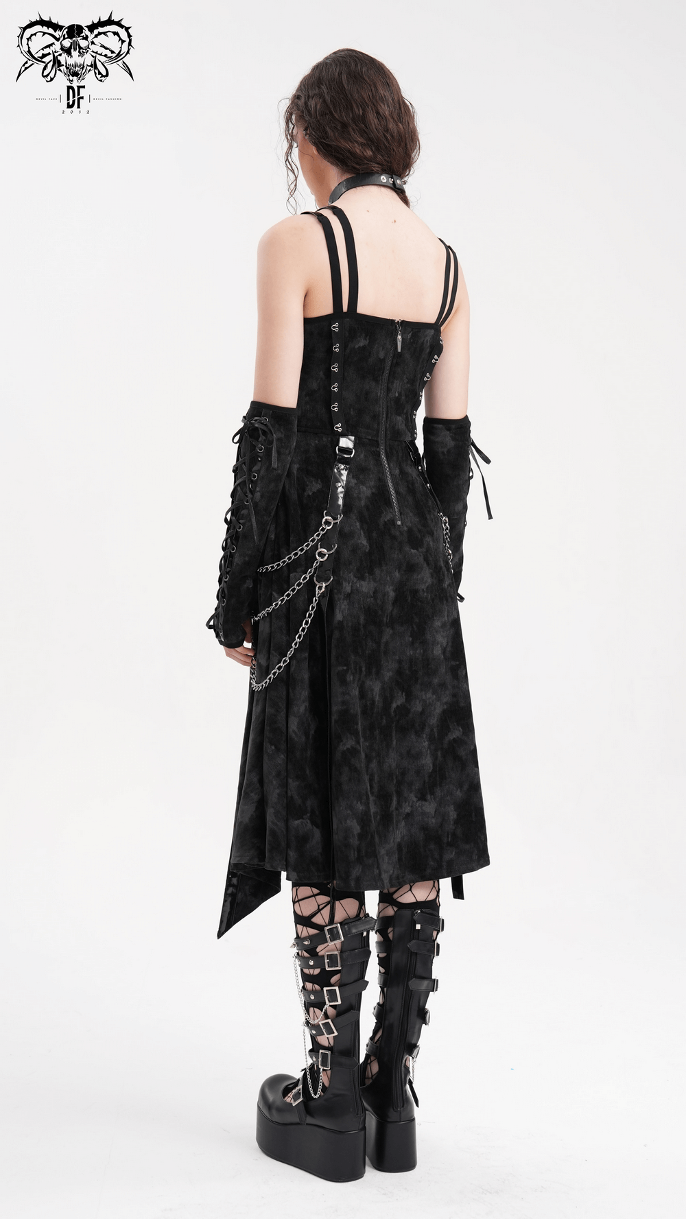 Back view of a woman in a gothic slip dress with chains and gloves, featuring a high-low hem and edgy black velvet fabric.