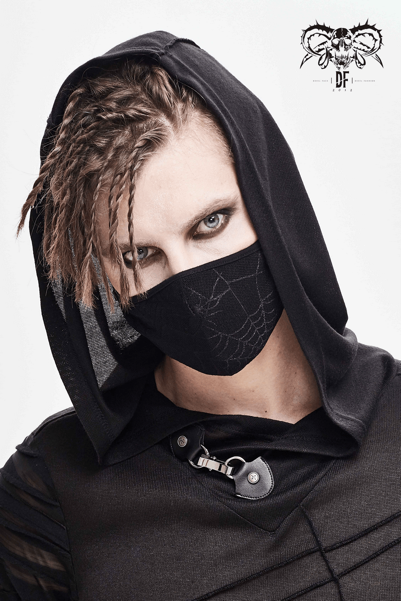 Gothic spiderweb face mask on stylish model wearing a black hooded outfit, showcasing a unique gothic accessory.
