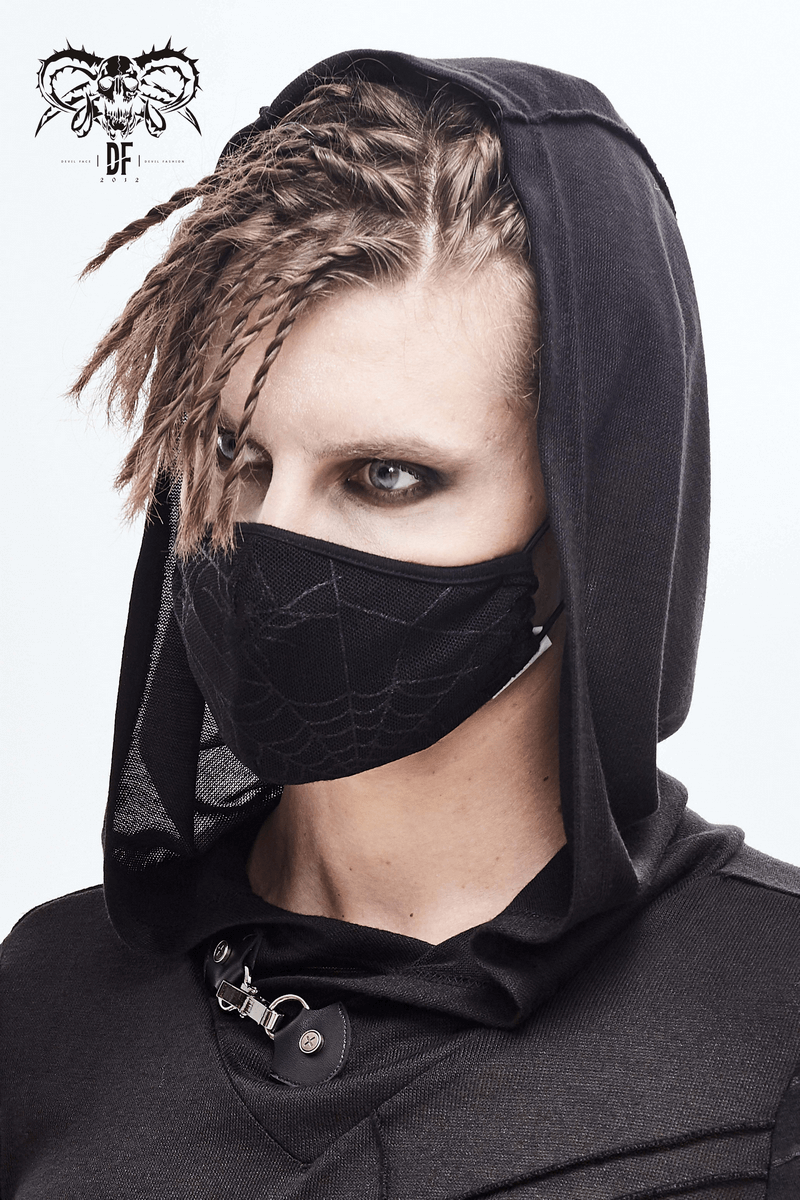 Gothic unisex black mask with spiderweb design worn by a stylish model in a hooded outfit.