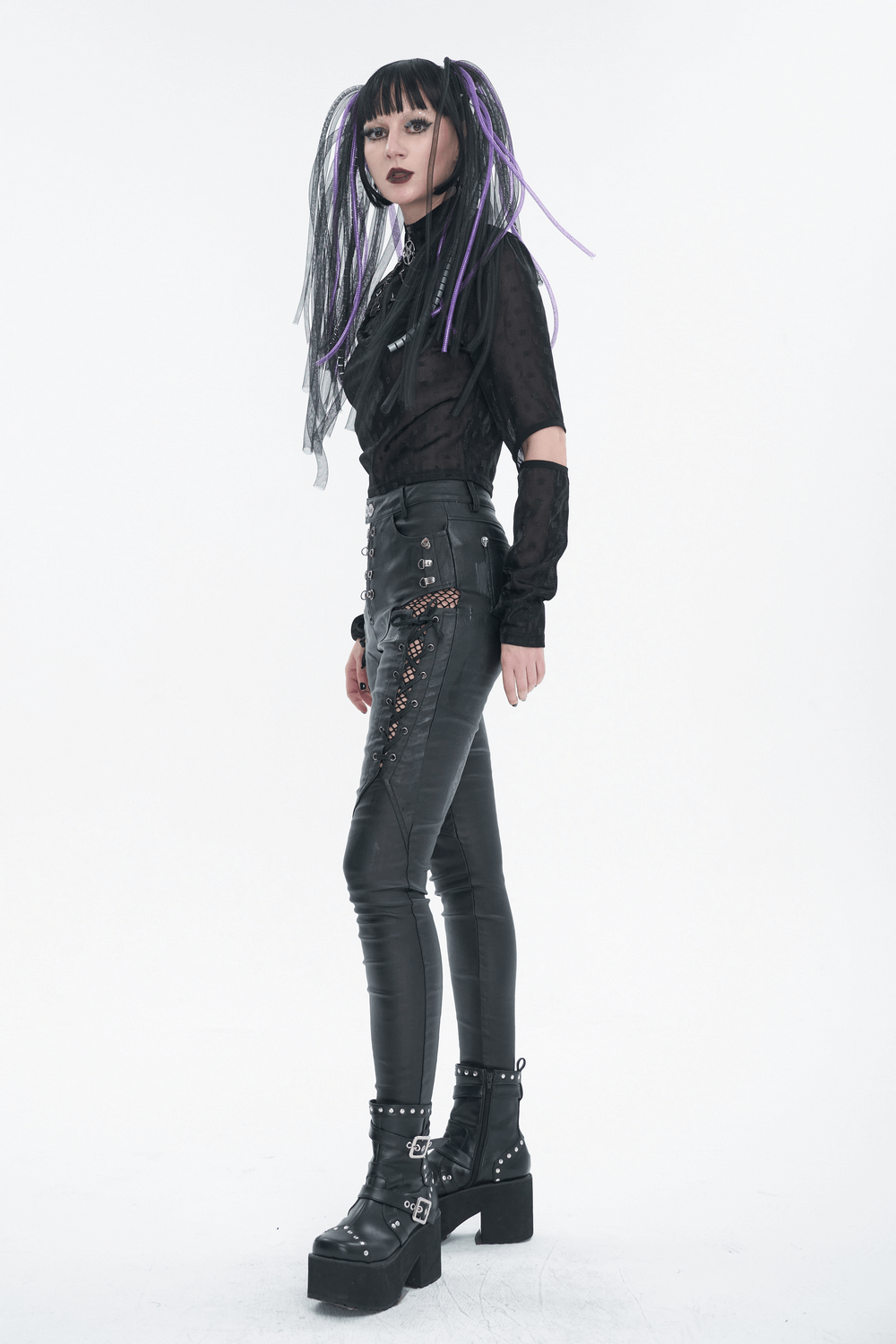 Gothic-inspired woman in black long sleeves and stylish pants, showcasing edgy fashion with unique accessories.