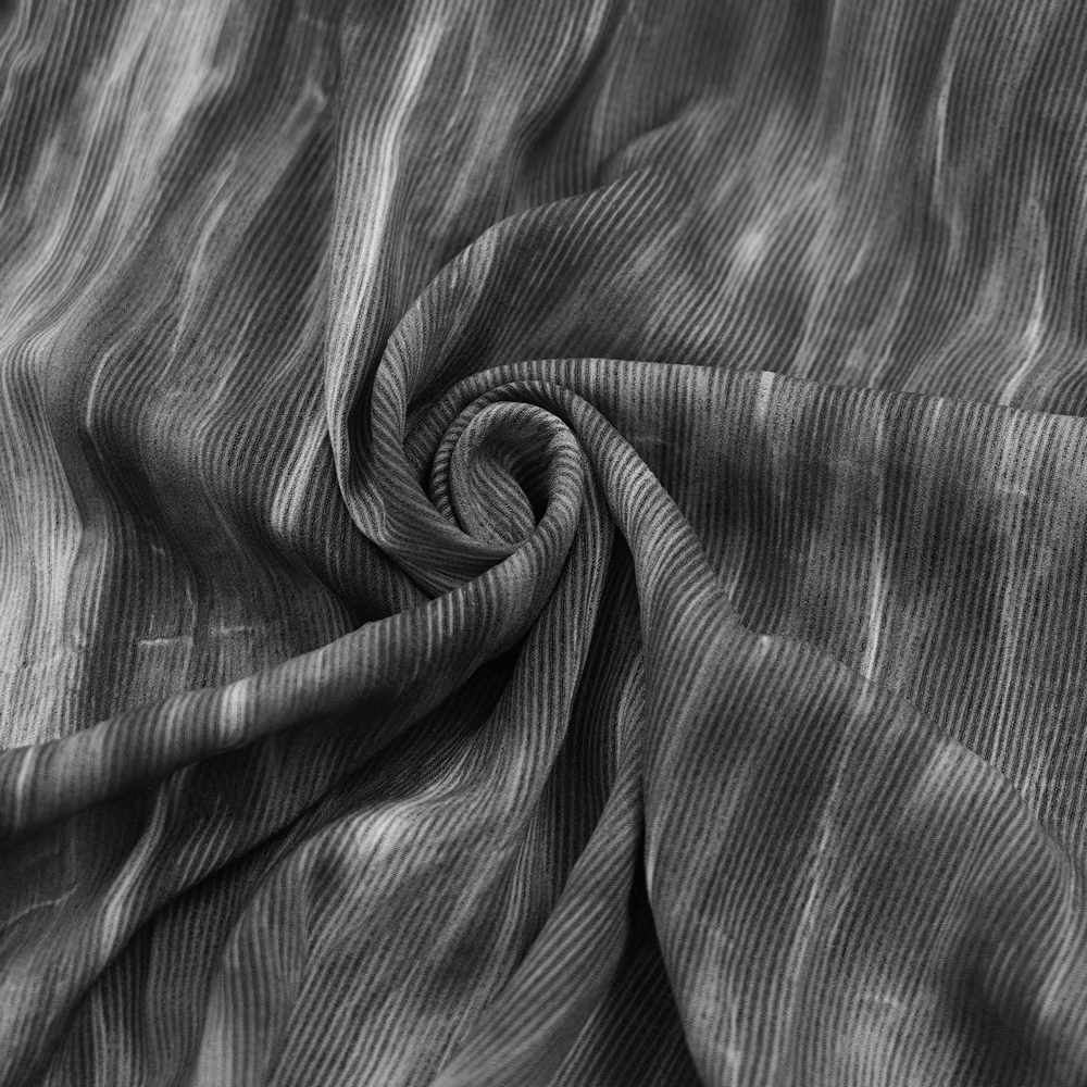 close-up of swirling black and gray textured fabric, showcasing soft pleats and intricate patterns for fashion design.