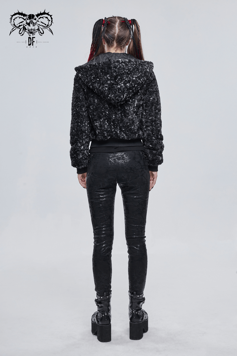 Back view of a woman in a black gothic strappy jacket with hood and shiny black leggings, showcasing stylish details.