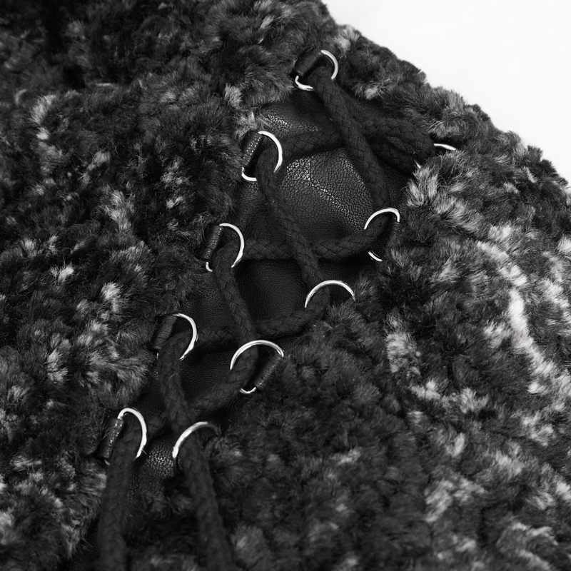 Close-up of gothic strappy design on a black warm women's jacket, showcasing intricate lace detailing.