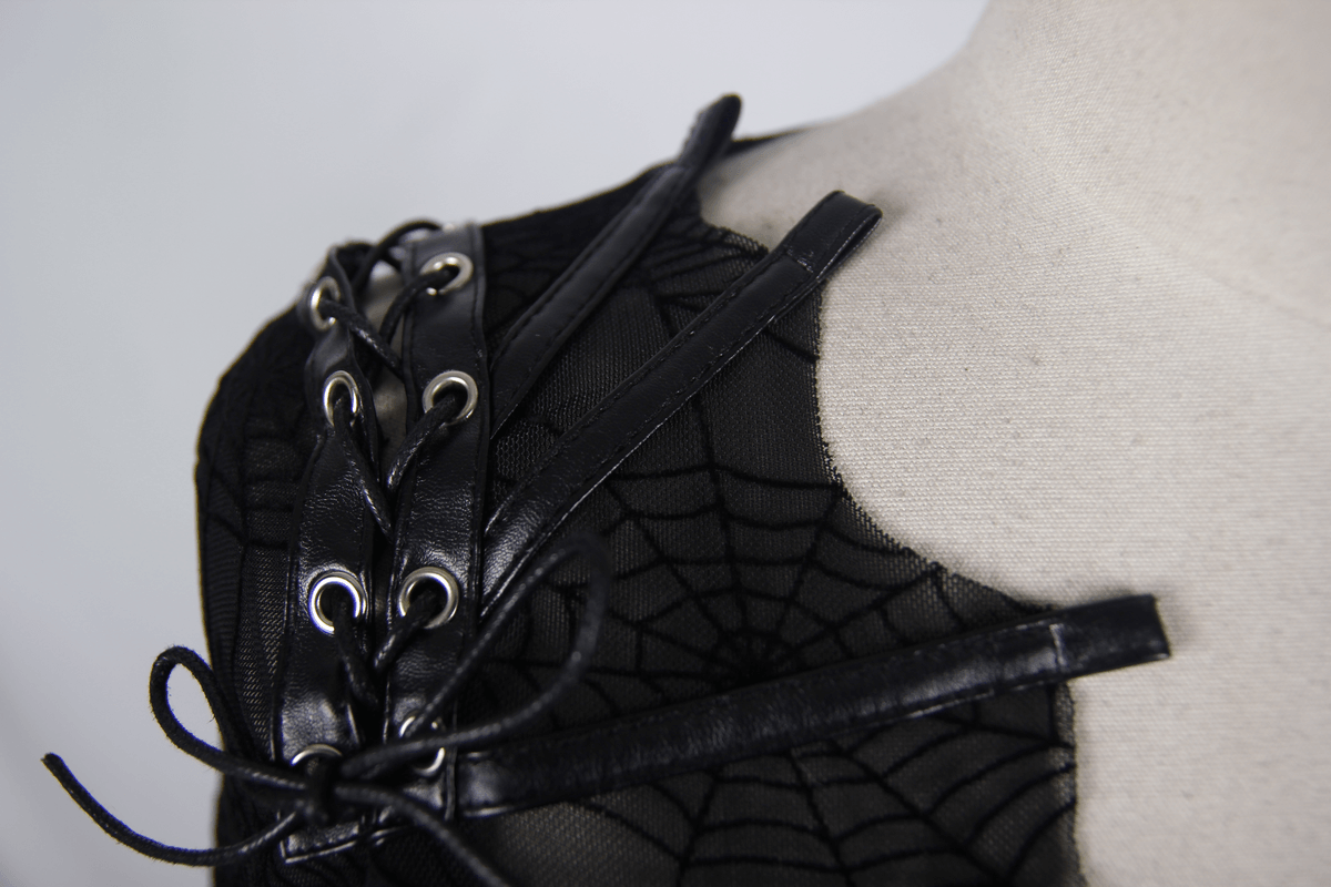 Close-up of a gothic black top featuring faux leather lacings and lace cobweb design on mesh fabric.