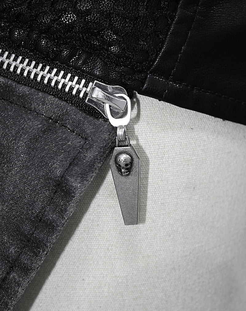 Close-up of gothic coat zipper featuring a coffin charm with skull, showcasing unique gothic fashion details.