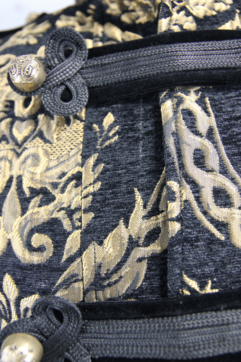 Close-up of luxurious gothic embroidery in gold on a vintage men's sleeveless coat.
