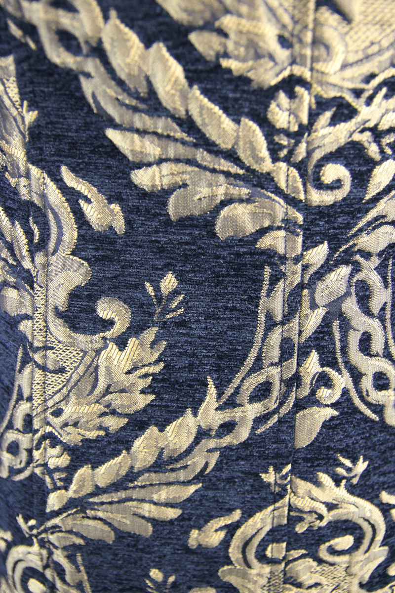 Close-up of luxurious gothic style embroidery in gold on deep blue fabric for vintage coats.