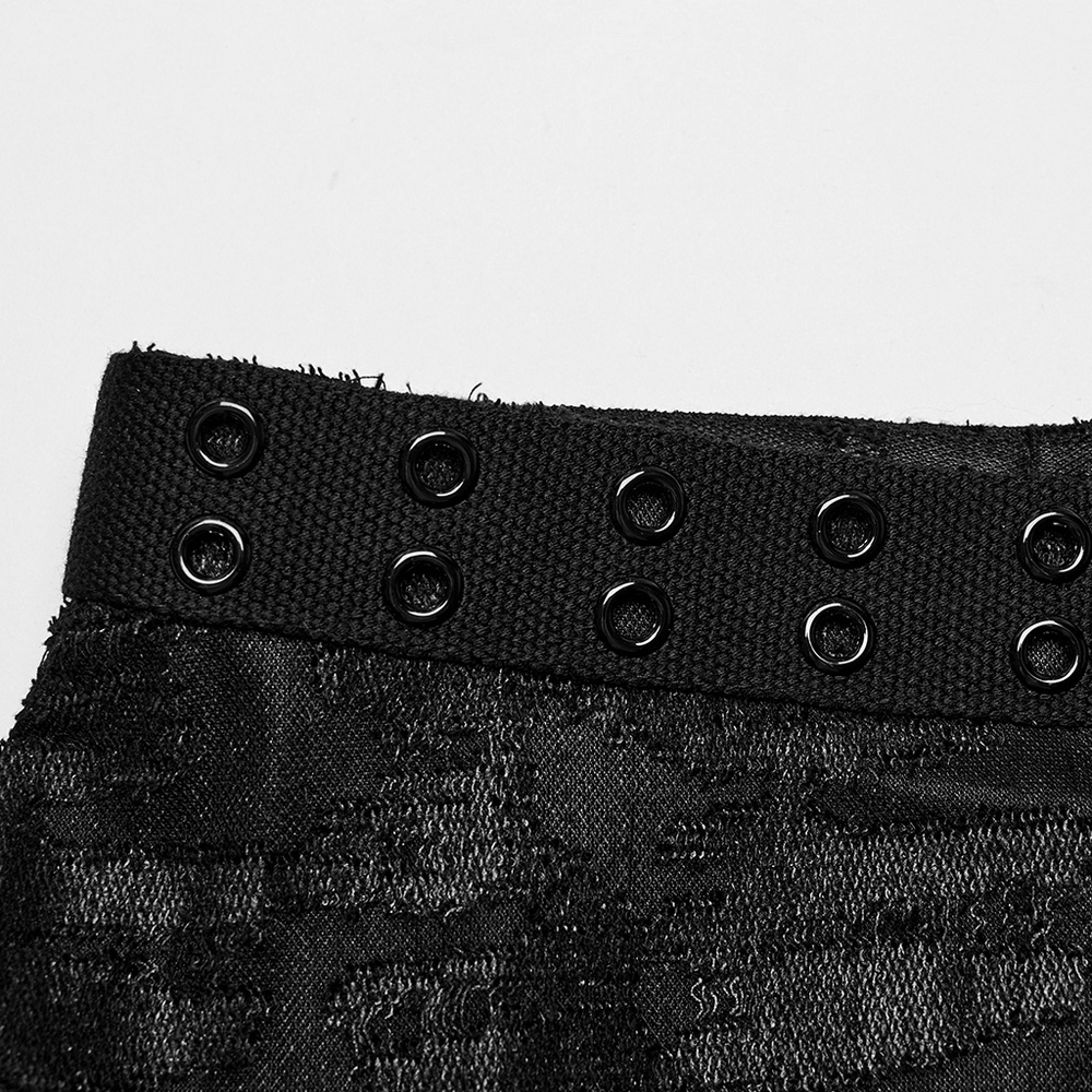 Close-up of black Gothic eyelet tank top fabric with intricate tattered texture and eyelet detail, showcasing edgy fashion design.