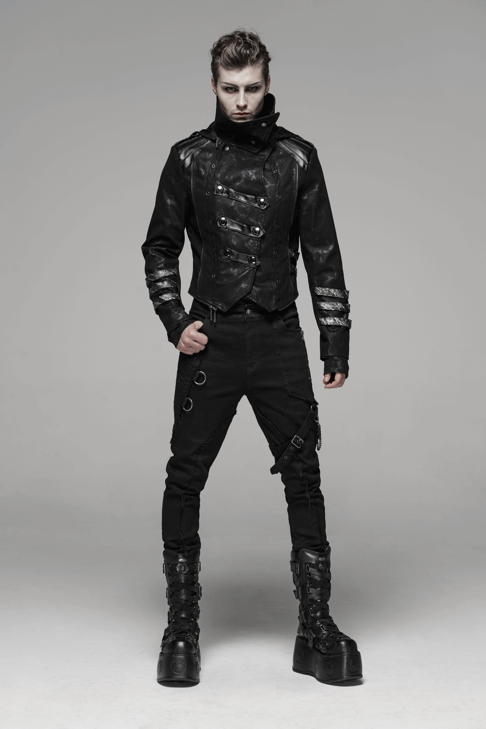 Stylish model in a black gothic jacket with statement buckles and edgy pants, perfect for daring fashion statements.