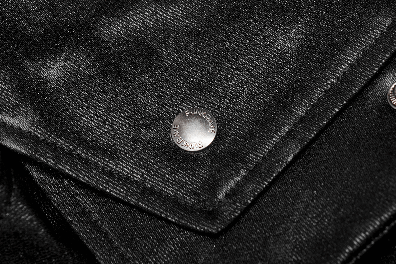 Close-up of silver punk-style buttons on a black coat, showcasing gothic fashion details.