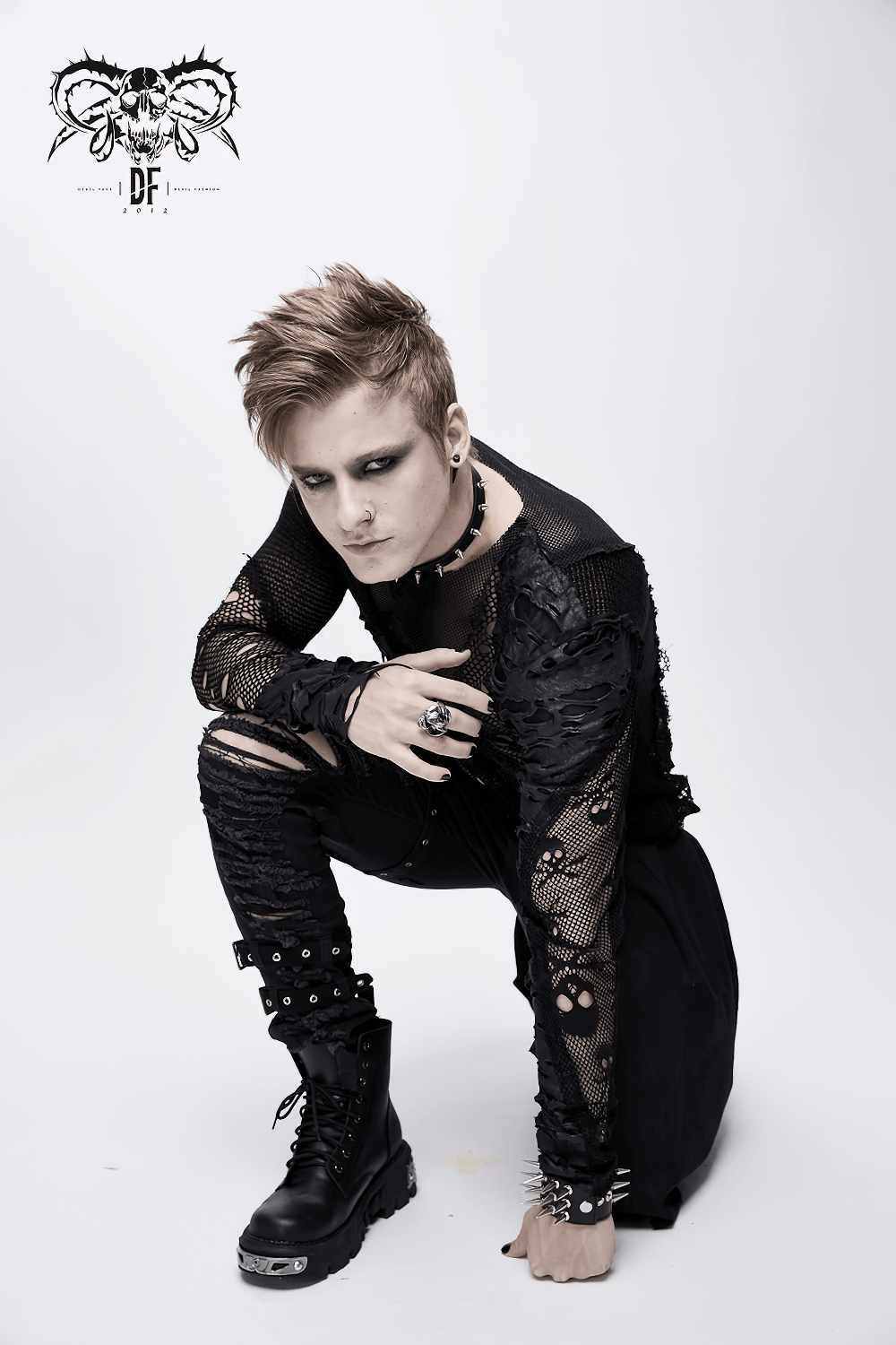 Gothic style men's black mesh top with torn details, skull pattern, and edgy accessories, perfect for alternative fashion.