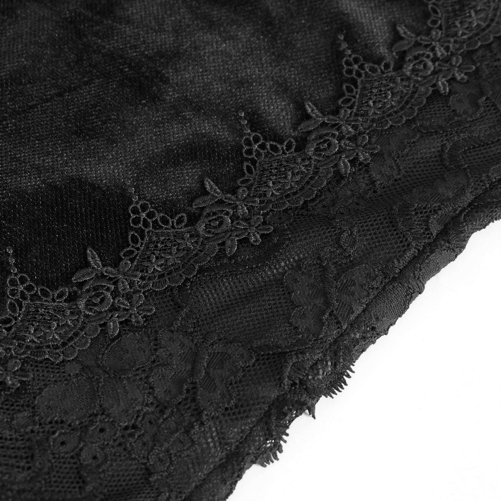 Close-up of black fabric with intricate lace overlay and floral accents, showcasing gothic-style elegance.