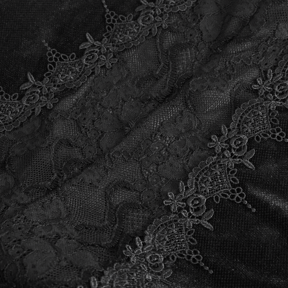 Close-up of intricate black lace detailing with floral accents on a gothic-style fabric.