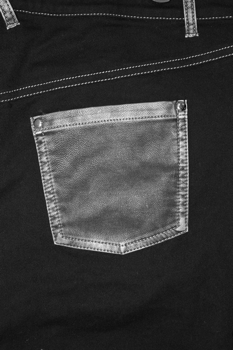 Close-up of a black jeans pocket featuring a silver metal accent, highlighting gothic style design.