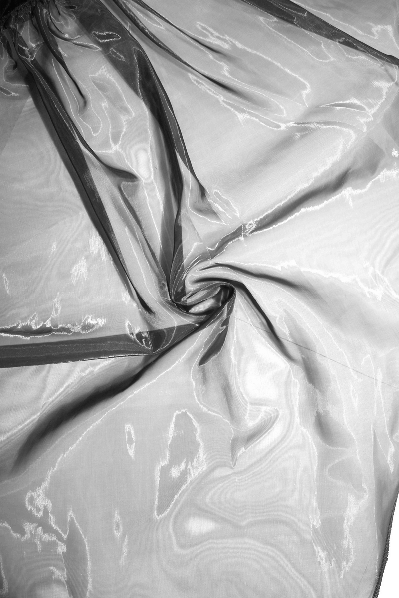 Close-up of elegant, transparent lace fabric showcasing soft sheerness and delicate texture for gothic-style apparel.