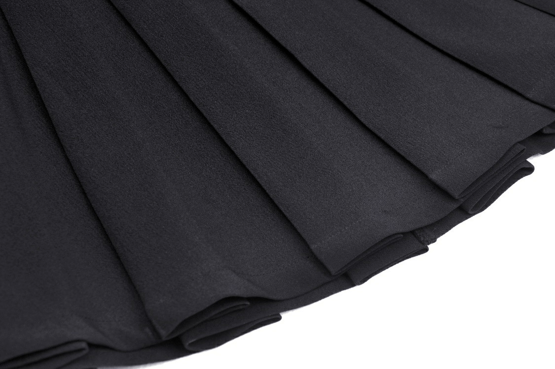 Close-up of a gothic black pleated mini skirt showcasing lace-up details and buckle accents.