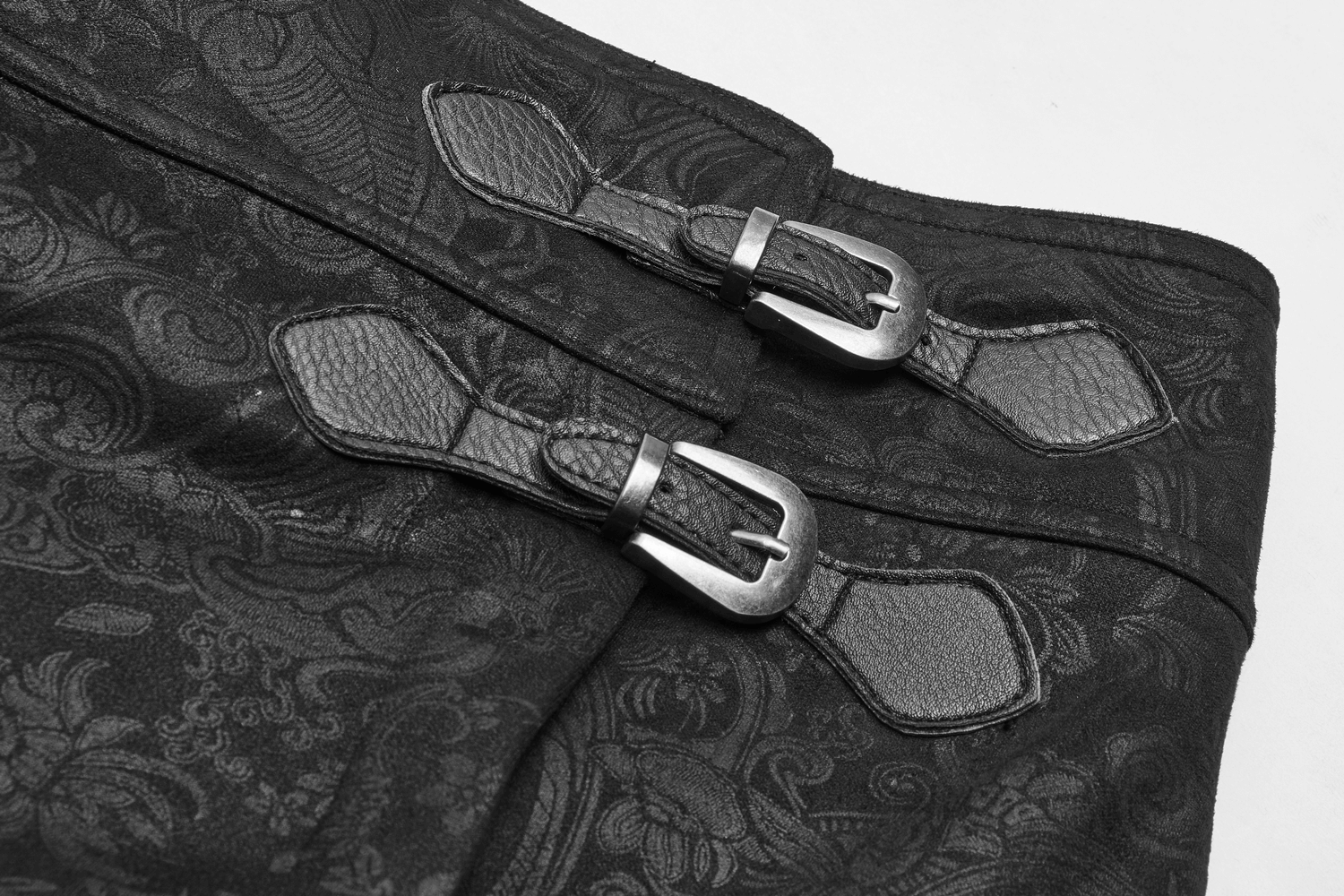 Close-up of gothic floral suede and leather long overskirt featuring decorative buckles.