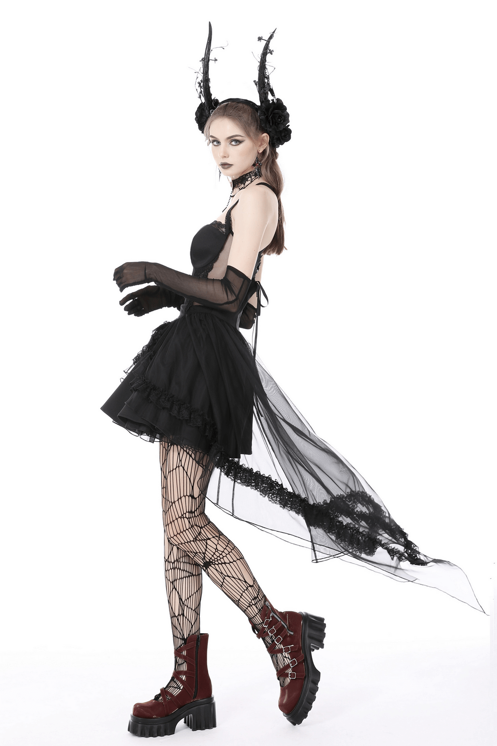 Model wearing a gothic swallowtail dress with lace, layered skirt, and dark accessories, showcasing dark elegance.