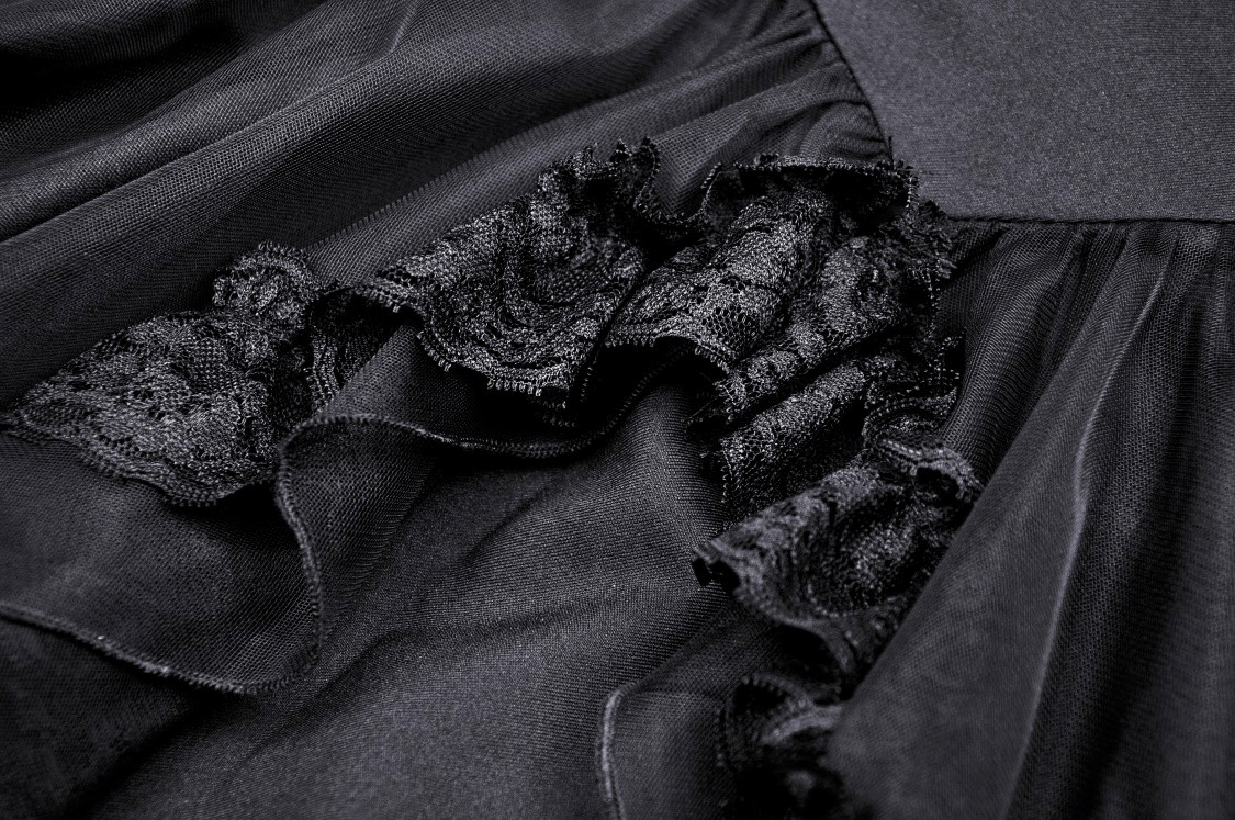 Close-up of black lace and layered fabric detail from a gothic swallowtail dress.