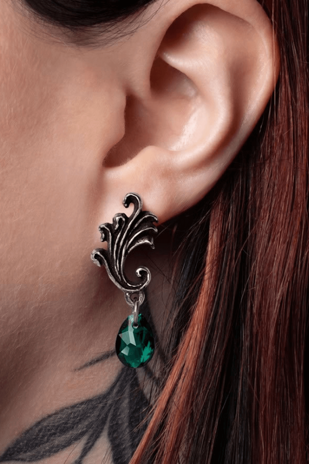 Gothic swirl earrings with Ivy green crystal drop, showcasing elegance and baroque design on a model's ear.