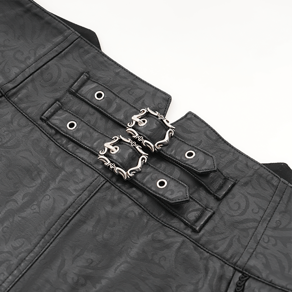 Close-up of adjustable double-buckle detail on gothic synthetic leather slim-fit pants with embossed pattern.