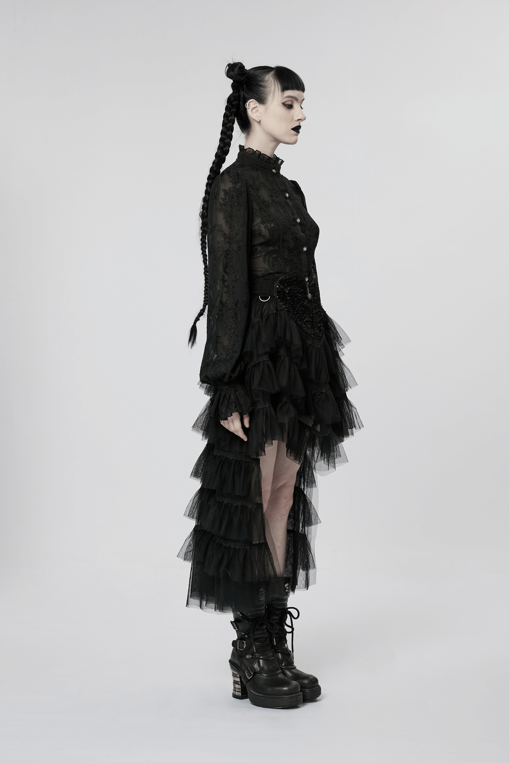 Side view of a model wearing a Gothic Tiered Tulle Ruffle Skirt, paired with a lace top and edgy combat boots.