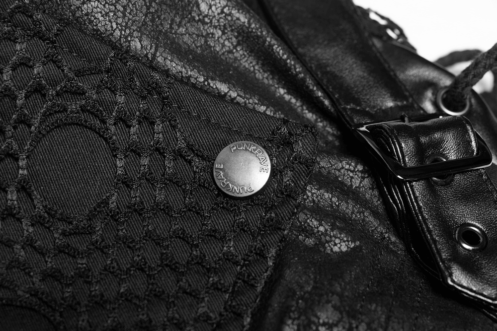 Close-up of black leather trench coat showing intricate lace detail and metallic button.