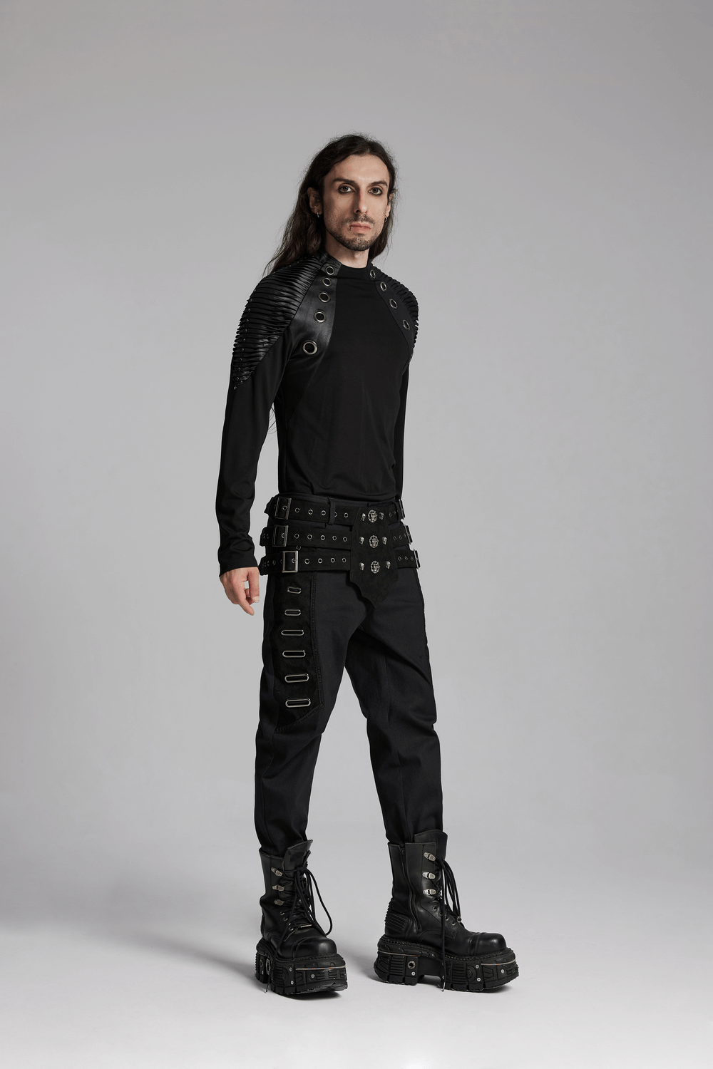 Model in edgy black punk outfit with textured sleeves and statement boots, showcasing alternative fashion style.