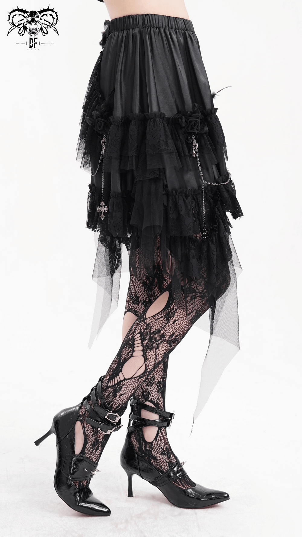 Gothic black tulle skirt with lace details, layered design, and edgy chains, paired with stylish heels and fishnet stockings.