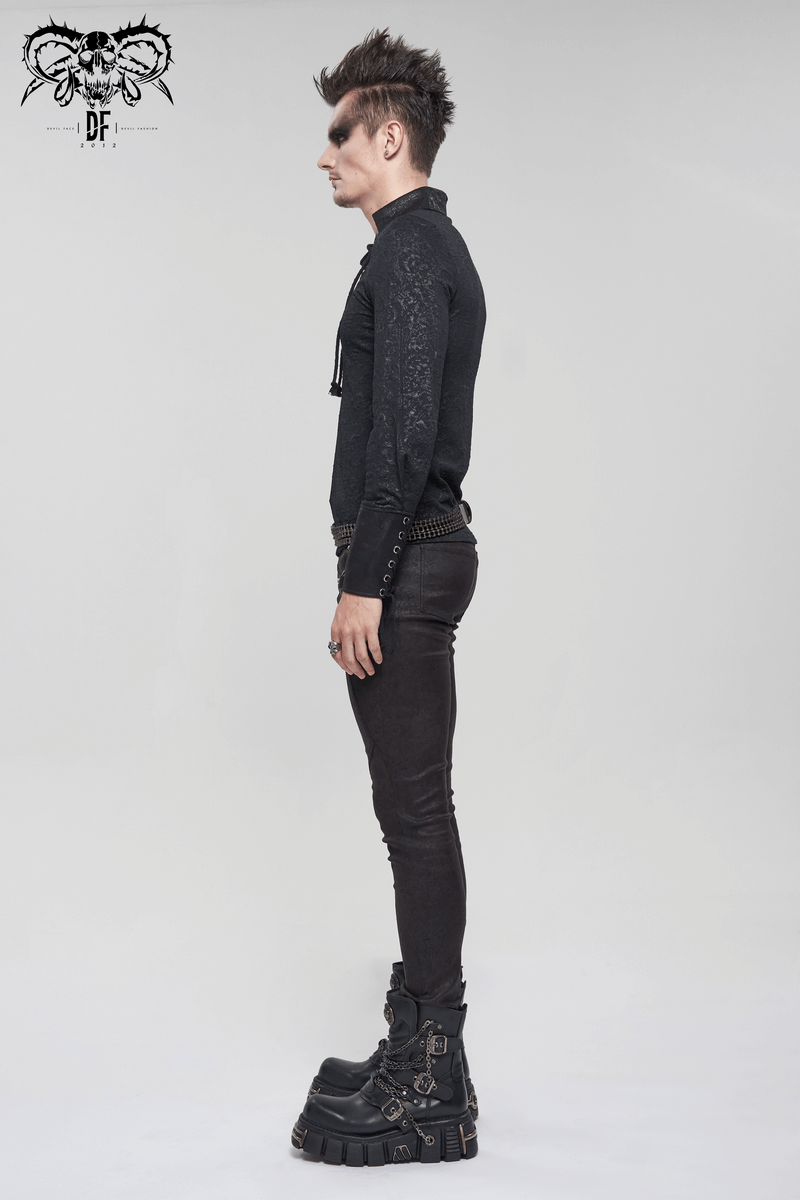 Side view of a man in a gothic black shirt with lace-up detail and stylish pants, showcasing a vintage punk look.