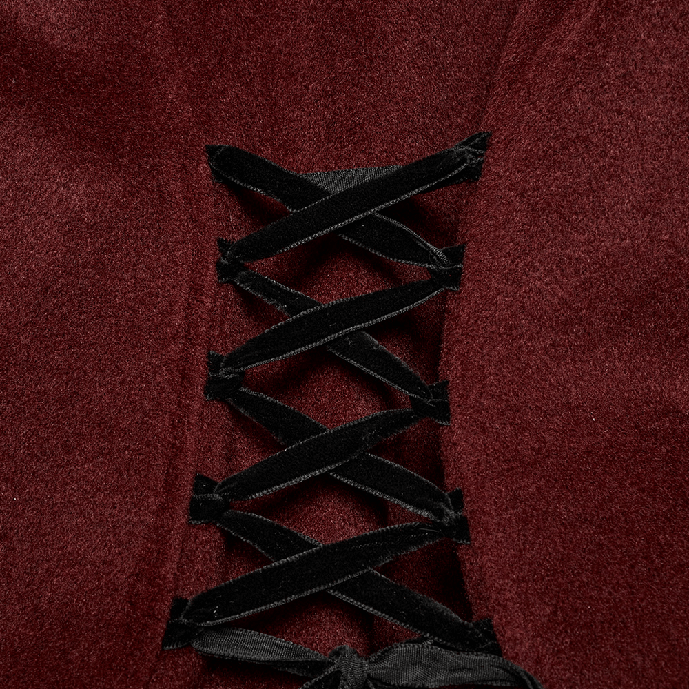 Close-up of gothic coat detailing with dark laces on rich red fabric, showcasing elegant craftsmanship.